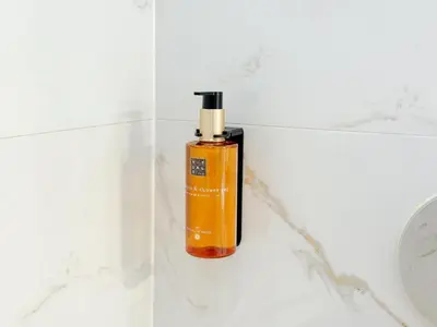an orange bottle of soap sitting next to a toilet at Old Town - Rajska Signature Suites by Gio Loft in Kraków