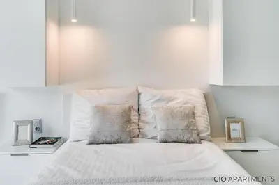a white bed with two pillows on top of it at Old Town - Rajska Signature Suites by Gio Loft in Kraków