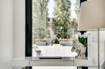a table with a vase of flowers and a window at Old Town - Rajska Signature Suites by Gio Loft in Kraków