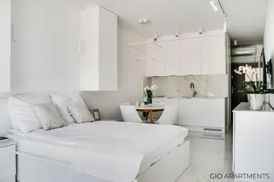 a white kitchen with a large white bed in a room at Old Town - Rajska Signature Suites by Gio Loft in Kraków