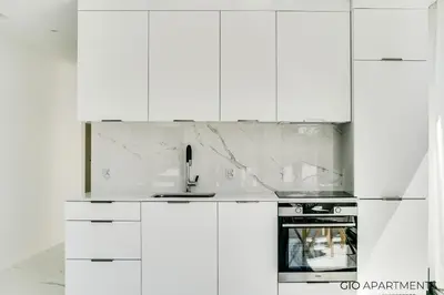 a white kitchen with a sink and a stove at Old Town - Rajska Signature Suites by Gio Loft in Kraków