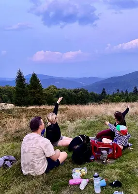 a group of people sitting in the grass at Przysiółek Flądrówka - Dom na odludziu z widokiem na Gorce i Tatry in Szczawa