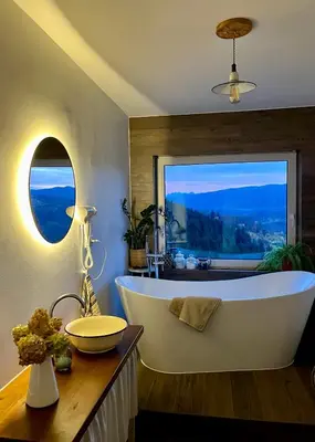 a large bath tub in a bathroom with a window at Przysiółek Flądrówka - Dom na odludziu z widokiem na Gorce i Tatry in Szczawa