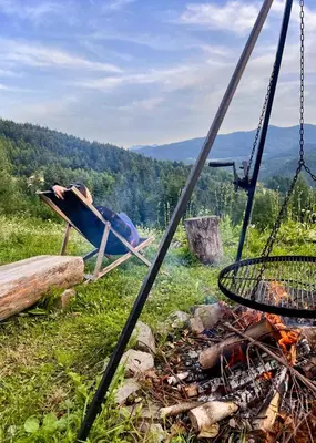 a chair next to a fire and a grill at Przysiółek Flądrówka - Dom na odludziu z widokiem na Gorce i Tatry in Szczawa