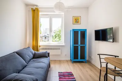 a living room with a blue couch and a table at Mickiewicza Old Town Apartment WAWELOFTS in Kraków
