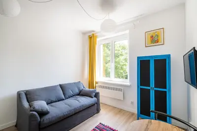 a living room with a blue couch and a window at Mickiewicza Old Town Apartment WAWELOFTS in Kraków