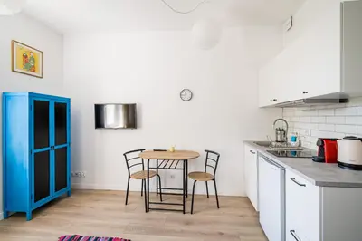 a kitchen with a table and chairs in a room at Mickiewicza Old Town Apartment WAWELOFTS in Kraków