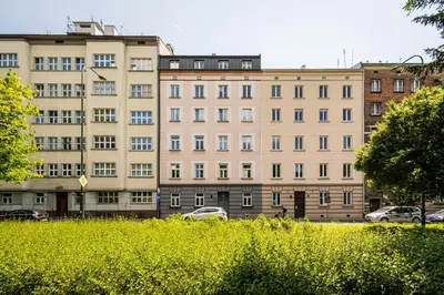 a large building with cars parked in front of it at Mickiewicza Old Town Apartment WAWELOFTS in Kraków