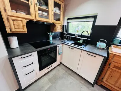 a small kitchen with white cabinets and a sink at Retro Domek - Domek z ogrodem w górach in Sułkowice