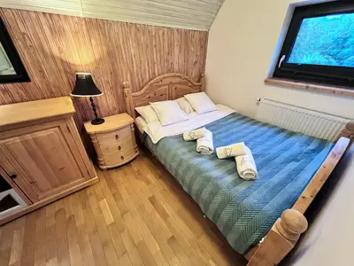 a small bedroom with a bed with towels on it at Retro Domek - Domek z ogrodem w górach in Sułkowice