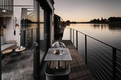 a table and chairs on a balcony with a view at New Port Aparthotel in Kraków