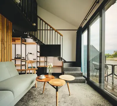 a living room with a balcony with a table with a candle at New Port Aparthotel in Kraków