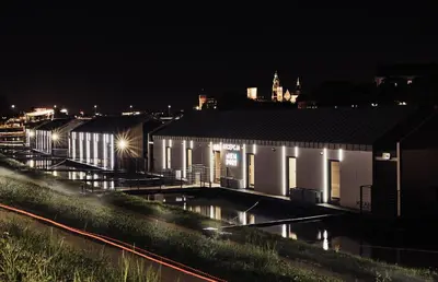 a building with a new dont sign on it at night at New Port Aparthotel in Kraków