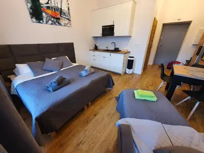 a bedroom with a bed and a kitchen with a table at Historic Old Town Kazimierz in Kraków