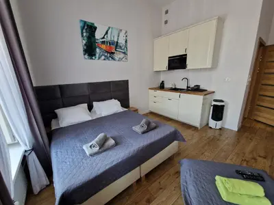 a small bedroom with a bed and a sink at Historic Old Town Kazimierz in Kraków