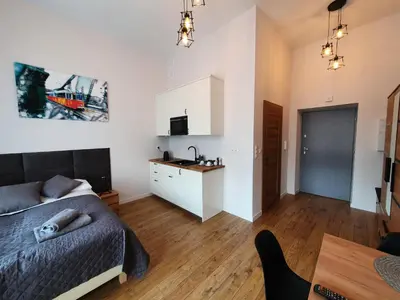 a bedroom with a bed and a table and a kitchen at Historic Old Town Kazimierz in Kraków