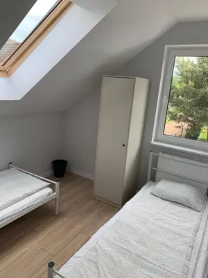 a attic bedroom with two beds and a window at Hostel Pokoje 15G in Skawina