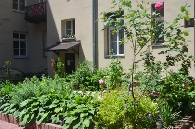 a garden in front of a building with flowers at Czar Prowansji - Comfy & Quiet near Rynek&Train Station Netflix in Kraków