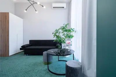 a living room with a couch and a table with a plant at Aquila Hotel in Zator