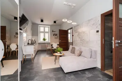 a living room with a white couch and a table at Apartament Papieski in Wadowice