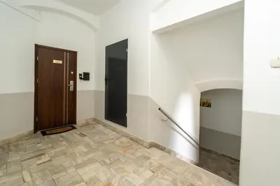 a hallway with a door and a tile floor at Apartament Papieski in Wadowice