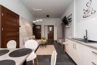 a kitchen and living room with a table and chairs at Apartament Papieski in Wadowice