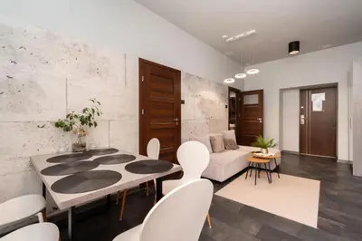 a living room with a table and white chairs at Apartament Papieski in Wadowice