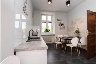 a kitchen and dining room with a table and chairs at Apartament Papieski in Wadowice