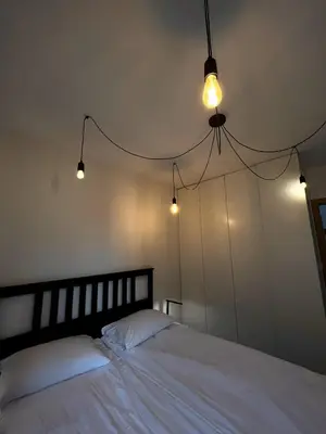 a bedroom with a white bed with lights on it at Apartament na Rydlówce in Kraków