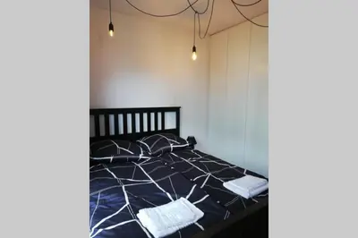 a bed with black and white sheets and pillows at Apartament na Rydlówce in Kraków