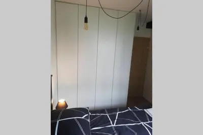 a room with a white wall and a black and white floor at Apartament na Rydlówce in Kraków