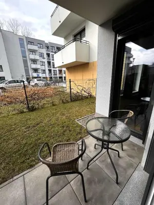 a patio with a table and chairs on a balcony at Apartament na Rydlówce in Kraków