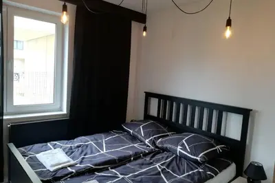 a bed with blue sheets and pillows in a bedroom at Apartament na Rydlówce in Kraków