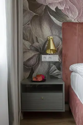 a lamp on a night stand next to a bed at Flav Apartment in Kraków