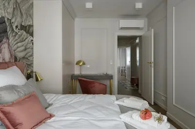 a bedroom with a white bed with pink pillows at Flav Apartment in Kraków