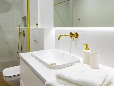 a white bathroom with a sink and a toilet at Golden Star Apartment in Kraków