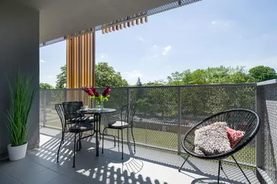 a balcony with chairs and a table with a view at Golden Star Apartment in Kraków