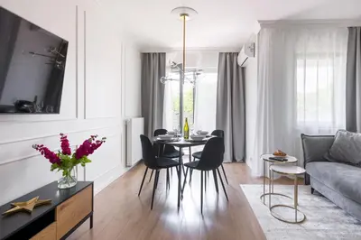 a living room with a table and chairs and a couch at Golden Star Apartment in Kraków