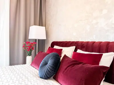 a bedroom with a bed with red and white pillows at Golden Star Apartment in Kraków