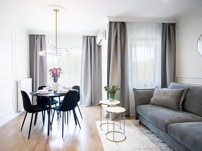 a living room with a couch and a table and chairs at Golden Star Apartment in Kraków