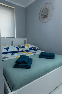 a bed with two blue pillows on top of it at Lovely place-apartament Oświęcim in Oświęcim