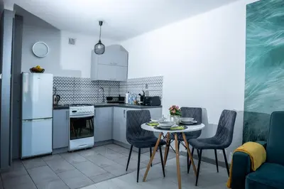 a kitchen with a table and chairs and a refrigerator at Lovely place-apartament Oświęcim in Oświęcim