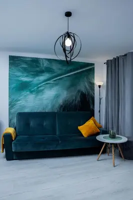 a blue couch in a living room with a painting at Lovely place-apartament Oświęcim in Oświęcim