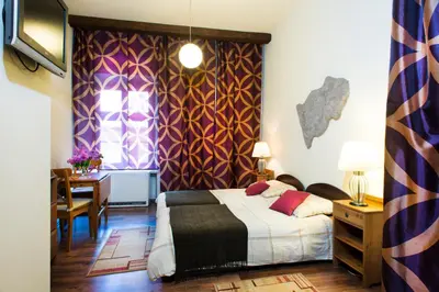 a bedroom with a bed and a desk and a window at Mikolajska Residence in Kraków