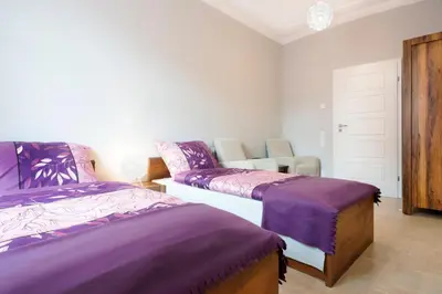 a bedroom with two beds with purple sheets at Mikolajska Residence in Kraków