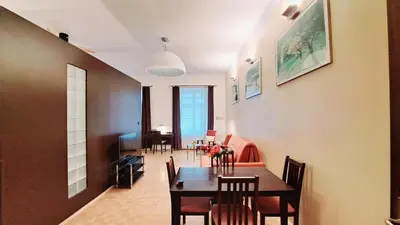 a dining room and living room with a table and chairs at Mikolajska Residence in Kraków