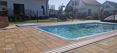a large swimming pool in a yard next to a house at Zator Lider House Energy in Zator