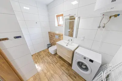 a white bathroom with a washing machine in it at Zator Lider House Energy in Zator