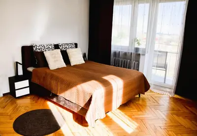 a bedroom with a bed and a large window at Travel Apartament Cracow in Kraków