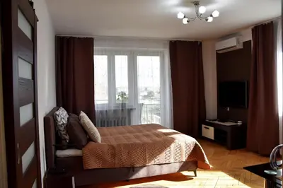 a bedroom with a bed and a large window at Travel Apartament Cracow in Kraków